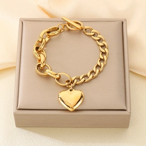 Detail of 18k gold plated heart pendant bracelet with toggle clasp on silk