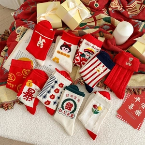 Close-up of festive red cotton socks with embroidery on a holiday blanket
