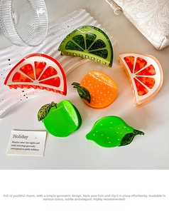 Detail of colorful fruit-shaped hair clips with glossy acetate finish and metal springs