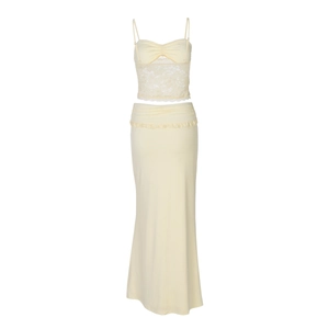 Detail of light yellow two-piece set featuring lace patchwork top and pleated maxi skirt