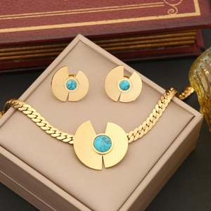 Detail of gold Cuban chain necklace and matching turquoise earrings in a jewelry box