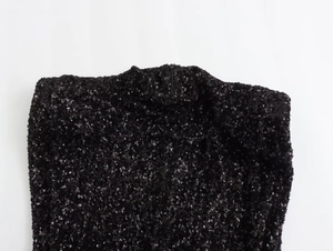 Detail of black sequined dress showing the high neck and back invisible zipper design