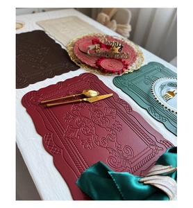 Macro detail of embossed retro floral patterns on assorted colorful leather placemats