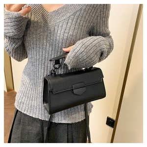 Detail of black structured crossbody bag with stone texture and matte shield lock