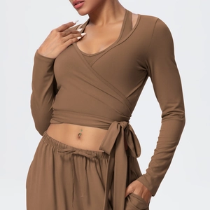 Detail of cross-wrap waist tie on brown long-sleeve yoga top and drawstring leggings