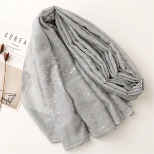 Close-up of lightweight grey scarf featuring gold leaf prints and rolled edges