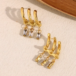 Macro detail of 18K gold plated earrings with triple claw design and rectangular zircon studs