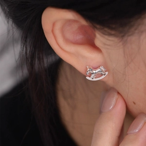 Detail showing high-quality silver rocking horse stud earring on model ear lobe