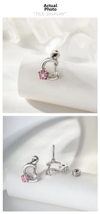 Detail of silver crescent moon piercing with pink star zircon and teardrop dangle