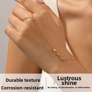 Détail de la gourmette main en or 18 carats avec cristaux ronds sur chaîne fine