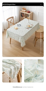 Detail of light green floral linen tablecloth featuring white daisies and cream fringe trim