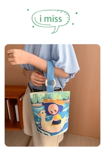 Detail of canvas bucket bag with light blue straps and wooden ring handle connectors