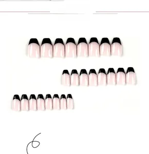 Detail view of 24 black French tip short ballerina press on nails on white background