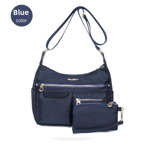 Detail of blue nylon crossbody bag set with gold zippers and small matching pouch
