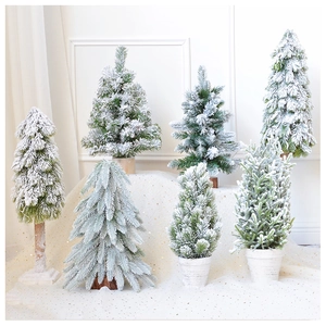 Detailed view of various flocked mini Christmas trees in green and white snowy tones