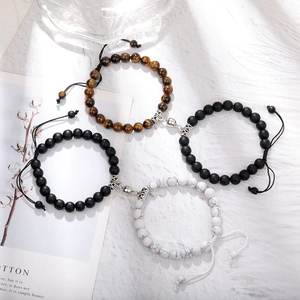 Detail of magnetic couple bracelets with tiger eye stones and adjustable woven cords