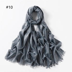Detail of greyish blue scarf with metallic silver shimmer and fringe edges