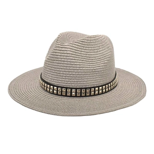 Close-up of light grey straw fedora hat featuring black band with gold square studs
