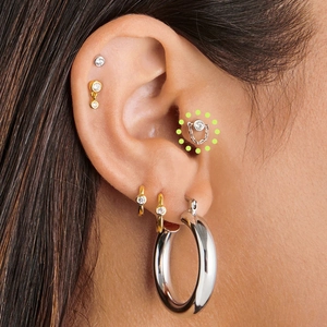 Detail of S925 sterling silver ear studs and hoops set with CZ stones on ear cartilage