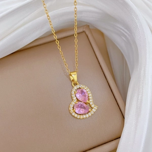 Close-up of pink heart pendant with crystals on silk background for luxury necklace
