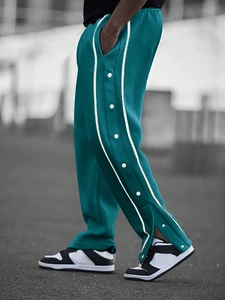 Detail of side white stripes and metal snap buttons on cyan-blue men's street casual pants