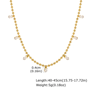 Detail view of gold bead chain necklace with seven white square zircon pendants and specs