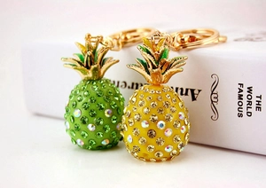 Detailed close-up of pineapple keychain featuring yellow and green crystals and gold ring