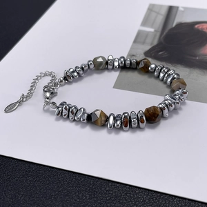 Detailed macro view of stainless steel bracelet with natural yellow tiger eye stone beads
