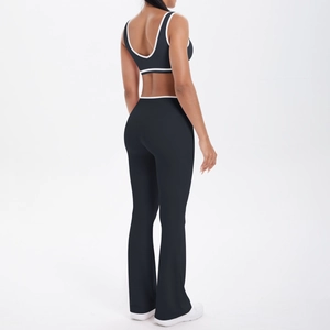 Close-up of black yoga set with white trim showing U-back bra and flared yoga pants