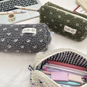 Détails de trousses en laine d'agneau pelucheuse à motifs de cœurs sur un bureau rangé