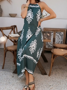 Detail des grünen Neckholder-Boho-Maxikleids mit Ethno-Print in sonniger Außenumgebung