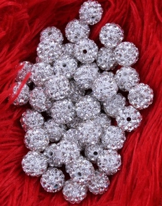Detailed close-up view of sparkling white rhinestone clay disco balls, perfect for DIY jewelry.