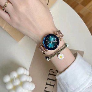 Elegant rose gold steel strap watch with a gradient blue dial on a female wrist