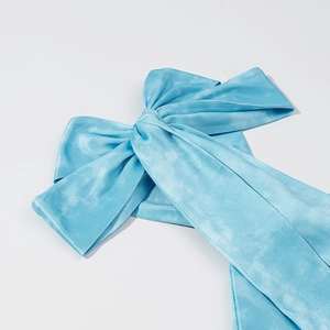 Detail of sky blue tie-dye satin halter top with elegant bow and silky texture