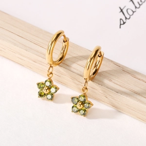 Titanium steel gold hoop earrings with green zircon flower pendants on wooden stand