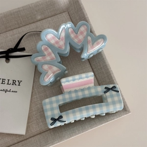 Detail of floral plaid hair claws with heart patterns and pink lace bow accents