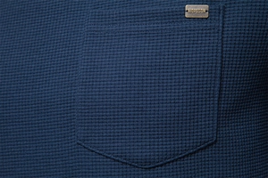 Close-up of waffle knit texture and pocket detail on dark blue men's cotton t-shirt