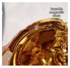 Close-up of a durable gold magnetic clasp on a heart-shaped bag for secure closure