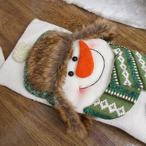 White knitted Christmas stocking with 3D snowman on wooden floor for holiday decor