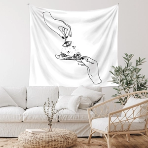 Close-up of a white tapestry with black line art hanging in a minimalist living room