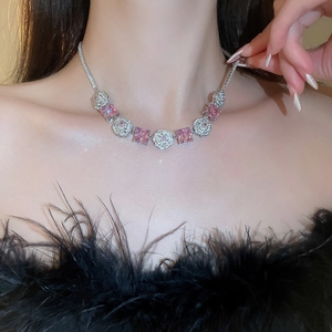Detail of necklace with pink square gemstones and silver floral zircon links on model