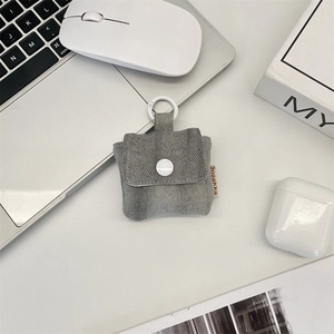 Detailed view of gray denim earphone pouch with snap closure and hanging clip
