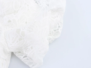 Nahaufnahme von weißer wasserlöslicher Spitze mit eleganten Hohlstickerei-Details