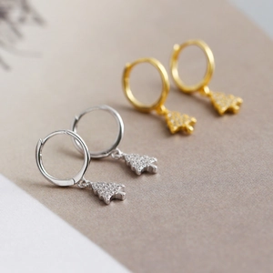 Macro detail of gold and silver Christmas tree drop earrings with sparkling cubic zirconia