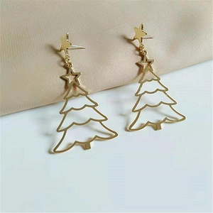 Elegant gold Christmas tree earrings with star stud detail on silk background