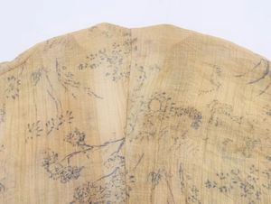 Close-up detail of vintage floral print blouse with lantern sleeves and V-neckline texture