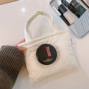Dettaglio della mini borsa trapuntata bianca con ricamo floreale 3D e etichetta Simple Wish
