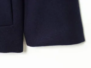 Detailed close-up showing the fine texture and high-quality stitching of the wool coat sleeve