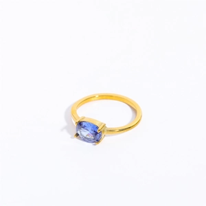 Detail of a gold stainless steel ring with a four-prong oval blue zircon setting