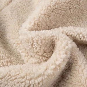 Gedetailleerde macro-opname van zachte crème sherpa fleece textuur van een winterjas
